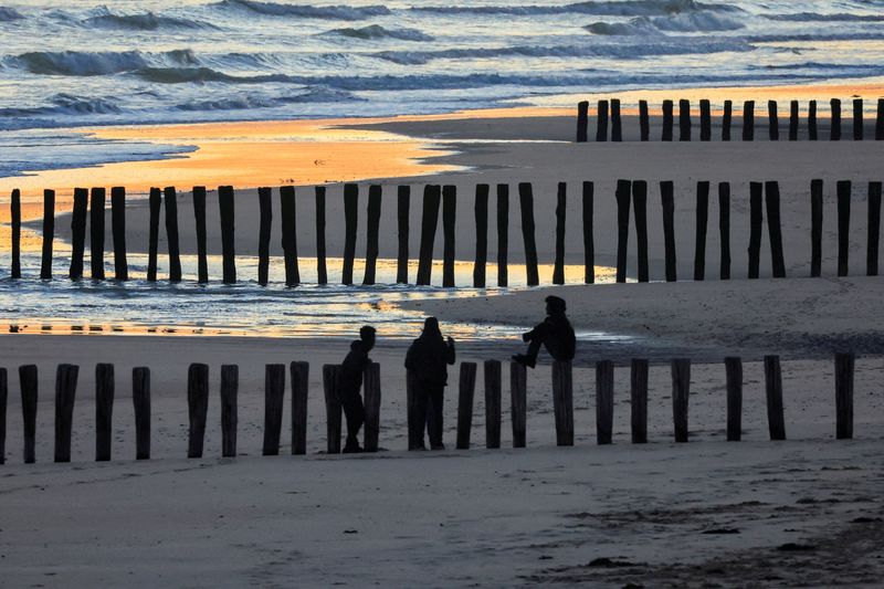 &copy; Reuters. Des migrants sur la plage au lever du soleil après une tentative ratée de traverser la Manche vers le Royaume-Uni sur un petit bateau, à Sangatte, près de Calais, France. /Photo prise le 10 août 2023/REUTERS/Pascal Rossignol/
