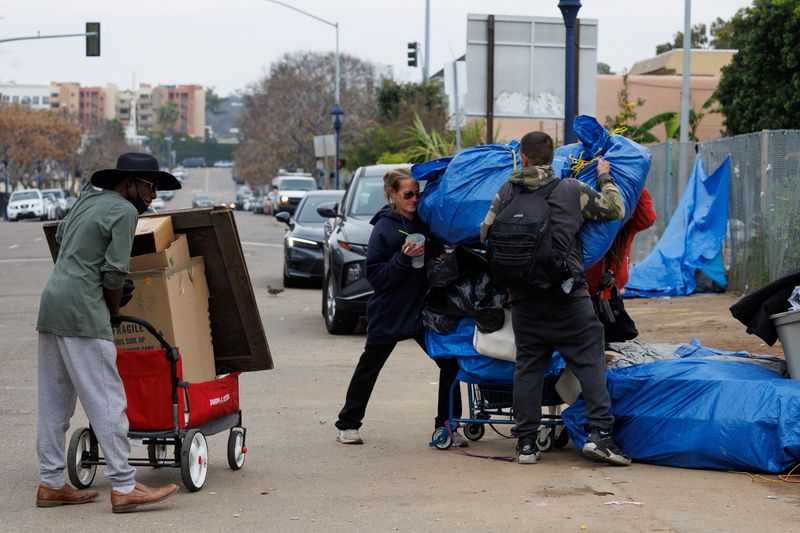&copy; Reuters. Homeless people move their belongings to the side of a freeway on land under state jurisdiction, after being evicted from a downtown location along side a city street, in San Diego, California, U.S., February 26, 2024.  REUTERS/Mike Blake