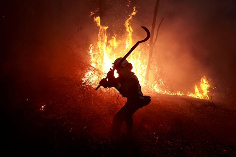 © Reuters. A firefighter from Galicia tackles a forest blaze during an outbreak of wildfires, following a prolonged dry spell and unseasonably high temperatrures, in Peidrafita, Asturias, Spain, March 31, 2023. REUTERS/Vincent West