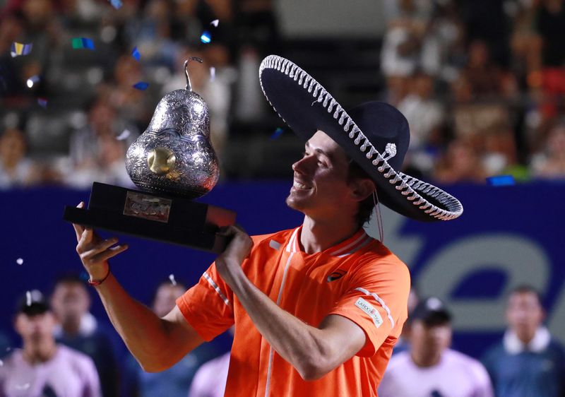 &copy; Reuters. لاعب التنس الأسترالي أليكس دي مينو يحتفل بالكأس بعد الفوز ببطولة أكابولكو المفتوحة للتنس في المكسيك يوم السبت. تصوير: هنري روميرو - رويترز.
