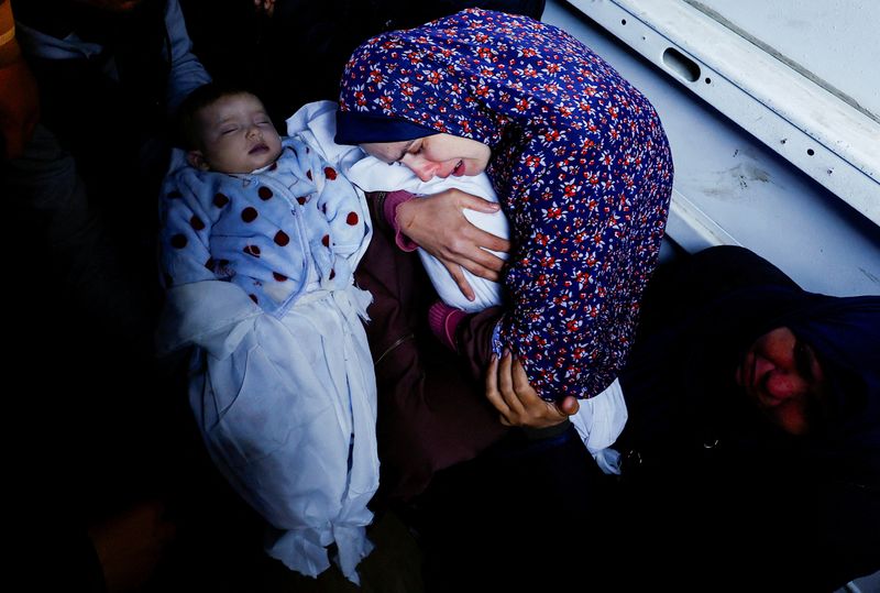 &copy; Reuters. والدة التوأمين الفلسطينيين وسام ونعيم أبو عنزة تحتضن جثمان أحدهما خلال جنازتيهما في رفح بجنوب قطاع غزة يوم الأحد. ولد التوأمان خلال الصراع 