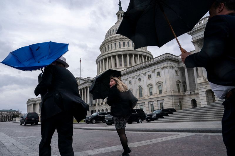 &copy; Reuters. FOTO DE ARCHIVO-Personas reaccionan al fuerte viento mientras caminan cerca del Capitolio de Estados Unidos, en Washington, Estados Unidos. 27 de febrero de 2024. REUTERS/Nathan Howard