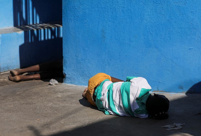 &copy; Reuters. Reclusos descansan en el suelo de la Penitenciaría Nacional tras los violentos enfrentamientos en la capital que han dañado las comunicaciones y provocado una fuga de presos de la penitenciaría principal en Puerto Príncipe, Haití. 3 de marzo de 2024.