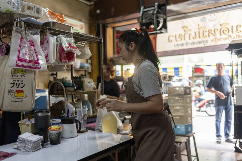 &copy; Reuters. FILE PHOTO: A woman works in a restaurant in Bangkok, Thailand September 11, 2023. Thailand's new government approved a raft of policies to lower the cost of living, suspend farmers' debts, draw more tourists and boost incomes. REUTERS/Jorge Silva/File Ph