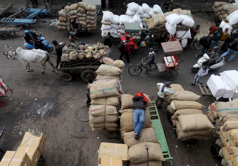 &copy; Reuters. A labourer sleeps on sacks as traffic moves past him in a wholesale market in the old quarters of Delhi, India, January 7, 2020. REUTERS/Anushree Fadnavis/file photo