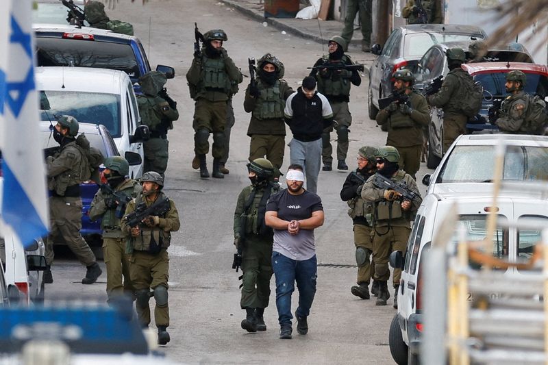 &copy; Reuters. Soldati israeliani arrestano dei palestinesi durante un raid a Ramallah, nella Cisgiordania occupata da Israele, il 4 marzo 2024. REUTERS/Mohammed Torokman