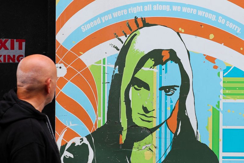 &copy; Reuters. FILE PHOTO: A man looks at an artwork depicting Irish singer Sinead O'Connor, who died at the age of 56, known for her chart-topping hit 'Nothing Compares 2 U', in Dublin, Ireland, July 27, 2023. REUTERS/Damien Storan/File Photo