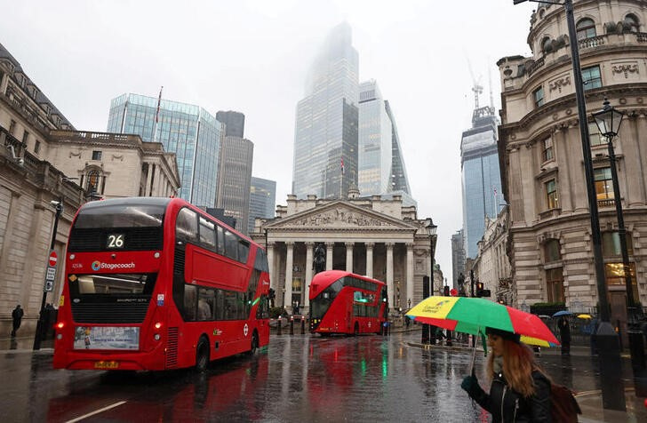 © Reuters. FILE PHOTO: Commuters walk as buses go past during the morning rush hour near the Bank of England in the City of London financial district in London, Britain, February 8, 2024. REUTERS/Toby Melville/File Photo