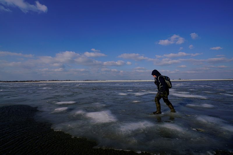 &copy; Reuters. FILE PHOTO: A person walks on ice on the Wadden Sea during the low tide near the island of Schiermonnikoog, the Netherlands, February 28, 2018. REUTERS/Cris Toala Olivares/File Photo