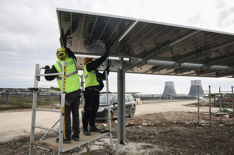 &copy; Reuters. Two workers install a bifacial 540 W solar panel at a solar panels park by energy supplier Enel Green Power, in Trino, Italy, March 5, 2024. REUTERS/Claudia Greco