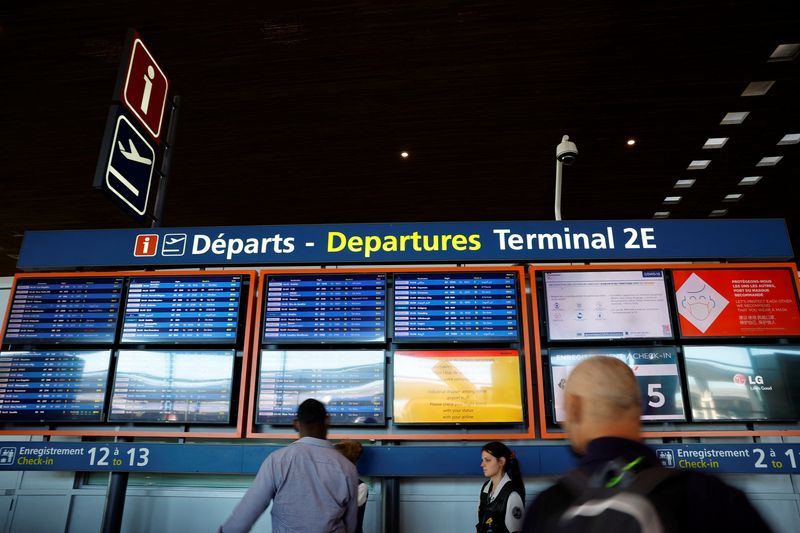 &copy; Reuters. FOTO DE ARCHIVO: Los pasajeros miran los horarios de salidas en la terminal 2E del aeropuerto de París-Charles de Gaulle en Roissy, cerca de París, mientras los trabajadores aeroportuarios franceses convocaban una huelga para protestar contra los bajos 