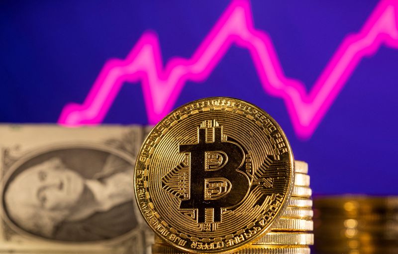 &copy; Reuters. FOTO DE ARCHIVO: Una representación de bitcoin delante de un gráfico de acciones y un dólar estadounidense en esta ilustración tomada, el 24 de enero de 2022. REUTERS/Dado Ruvic/Foto de archivo