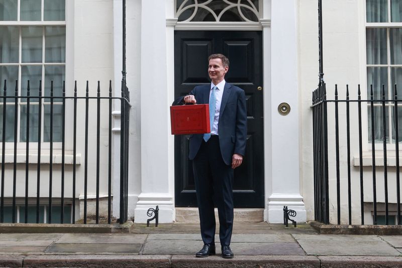 © Reuters. British Chancellor of the Exchequer Jeremy Hunt poses with the red budget box outside his office on Downing Street in London, Britain March 6, 2024. REUTERS/Hannah McKay