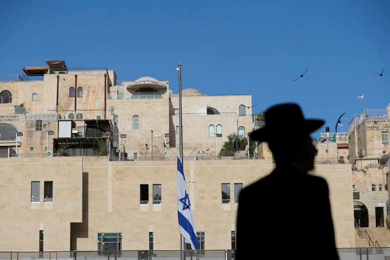 &copy; Reuters. FILE PHOTO: An ultra-Orthodox Jewish man is silhouetted near the Israeli national flag, which was lowered to half-mast as the country observes a day of mourning after dozens were crushed to death in a stampede at a religious festival on the slopes of Isra