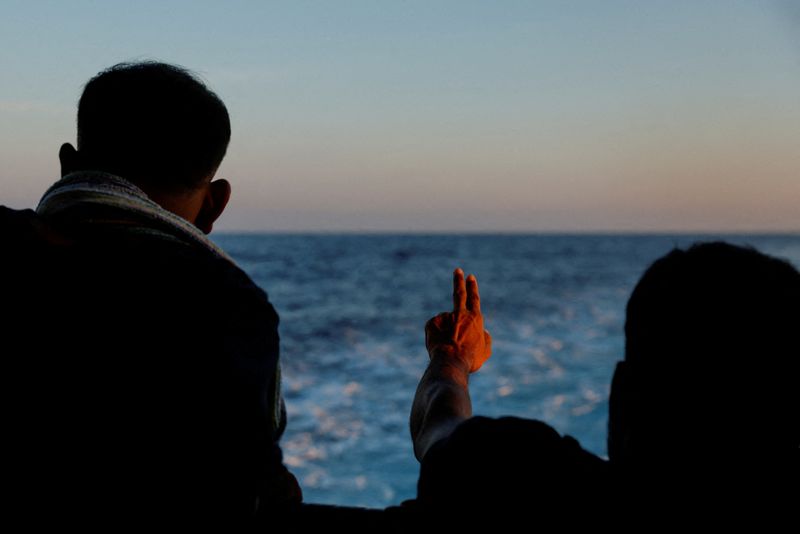 &copy; Reuters. مهاجر يلوح على متن سفينة لإنقاذ المهاجرين تابعة لمنظمة أطباء بلا حدود متجهة إلى إيطاليا بعد إنقاذ 61 مهاجرا كانوا على متن قارب خشبي في المياه