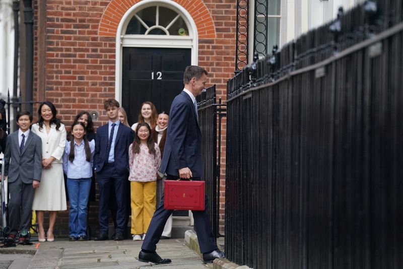 &copy; Reuters. Britain's Chancellor of the Exchequer Jeremy Hunt walks outside 11 Downing Street with his ministerial box before delivering his budget in the Houses of Parliament, in London, Britain, March 6, 2024. Stefan Rousseau/Pool via REUTERS