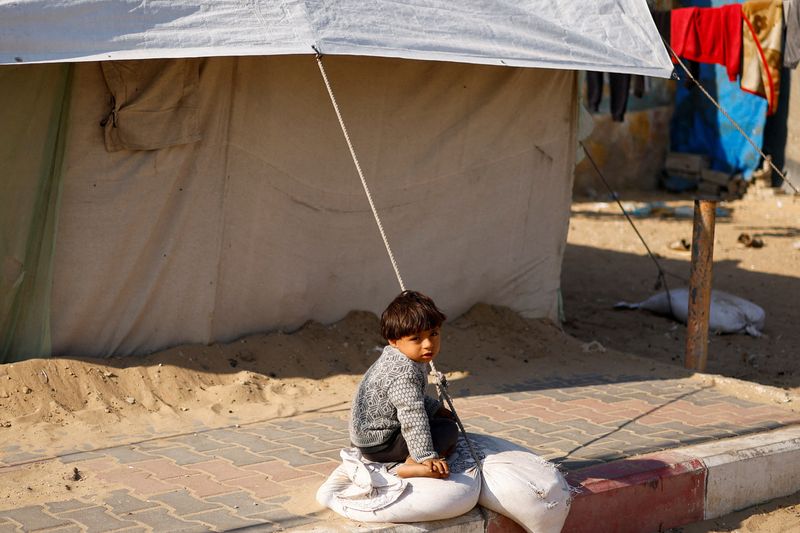 &copy; Reuters. Un niño refugiado sentado en el suelo en un campamento de tiendas de campaña, en medio del conflicto en curso entre Israel y Hamás, en Ráfah, en el sur de la Franja de Gaza. 27 de febrero de 2024. REUTERS/Ibraheem Abu Mustafa/File Photo