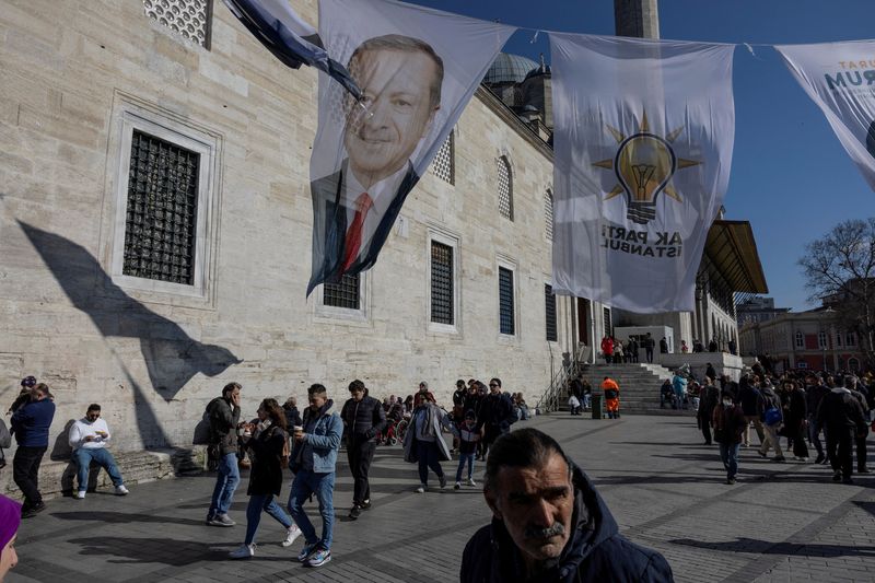 &copy; Reuters. FILE PHOTO: People walk under election posters for Turkey's President Tayyip Erdogan and his ruling AK Party (AKP) flags in Istanbul, Turkey, February 20, 2024. REUTERS/Umit Bektas/File Photo