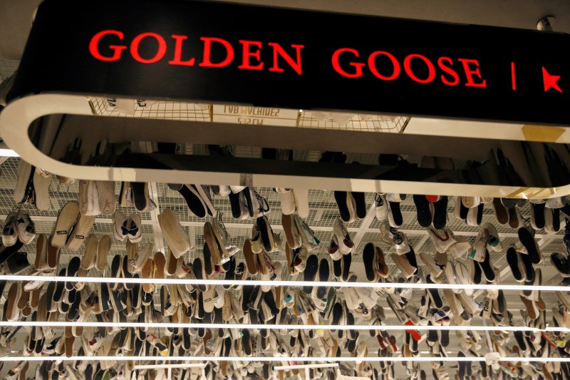 &copy; Reuters. Le sneakers del marchio italiano di alta moda Golden Goose sono appese vicino all'insegna del negozio a Pechino. REUTERS/Tingshu Wang/File Photo