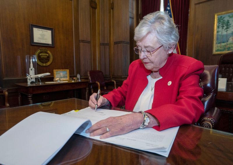 &copy; Reuters. FILE PHOTO: Alabama Governor Kay Ivey signs into law the Alabama Human Life Protection Act, after both houses of the legislature passed the bill, in Montgomery, Alabama, U.S., May 15, 2019.  Office of the Governor State of Alabama/Handout via REUTERS/File
