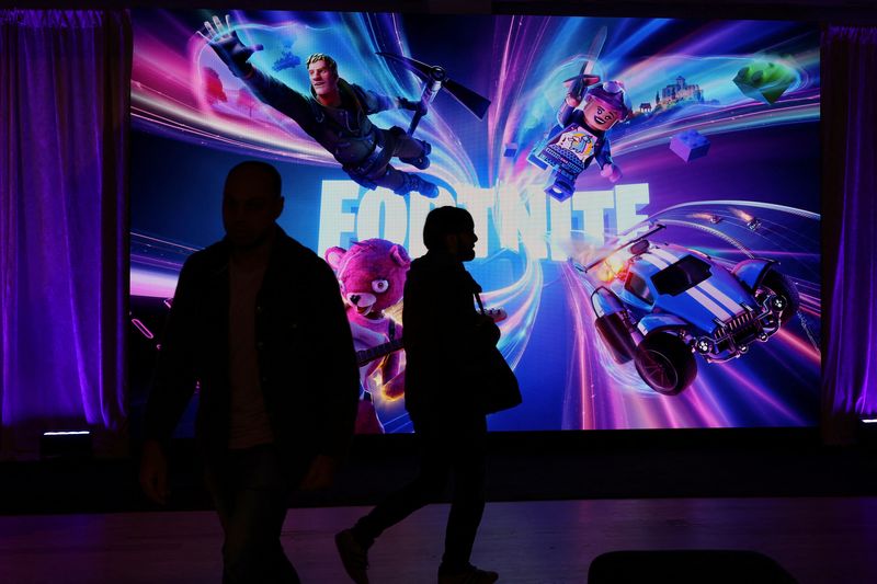 © Reuters. FILE PHOTO: People in silhouette walk by a Fortnite gaming digital monitor during an event in New York City, U.S., December 4, 2023.  REUTERS/Shannon Stapleton/File Photo