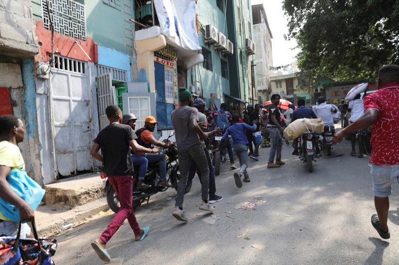 &copy; Reuters. Residents run after hearing gunfire as the government said it would extend a state of emergency for another month after an escalation in violence from gangs seeking to oust the Prime Minister Ariel Henry, in Port-au-Prince, Haiti, March 7, 2024. REUTERS/R
