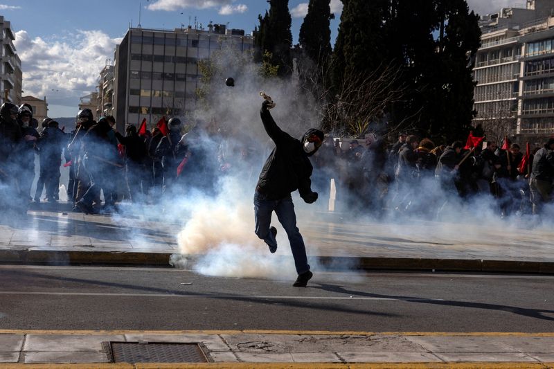 © Reuters. A demonstrator prepares to throw a projectile as Greek university students clash with riot police during a demonstration before the voting of a planned bill which opens the way for the operation of foreign private universities, in Athens, Greece, March 8, 2024. REUTERS/Alkis Konstantinidis    