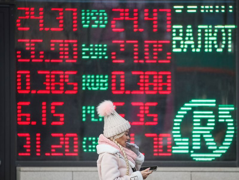 &copy; Reuters. FILE PHOTO: A woman walks past a board showing currency exchange rates in central Kiev, Ukraine January 27, 2020.  REUTERS/Gleb Garanich/File Photo