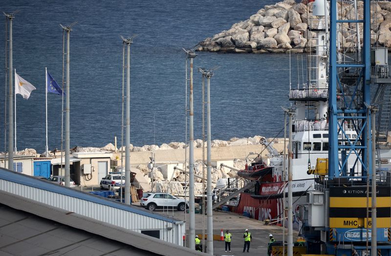 © Reuters. عمال يقفون بجوار سفينة إنقاذ تابعة لمنظمة أوبن آرمز الإسبانية غير الحكومية في ميناء لارنكا بقبرص يوم السبت. تصوير: يانيس كورت أوغلو - رويترز 
