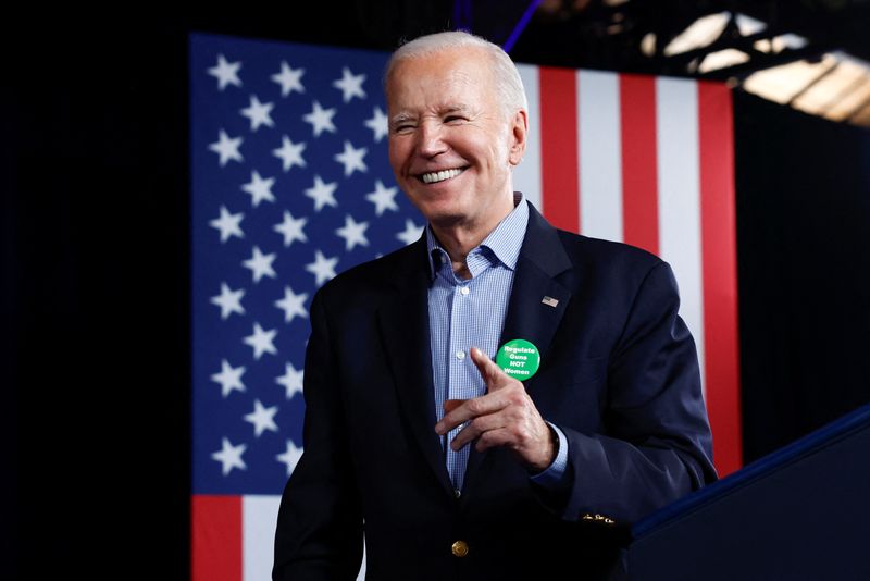 © Reuters. El presidente de Estados Unidos, Joe Biden, reacciona mientras luce una insignia en la que se lee 