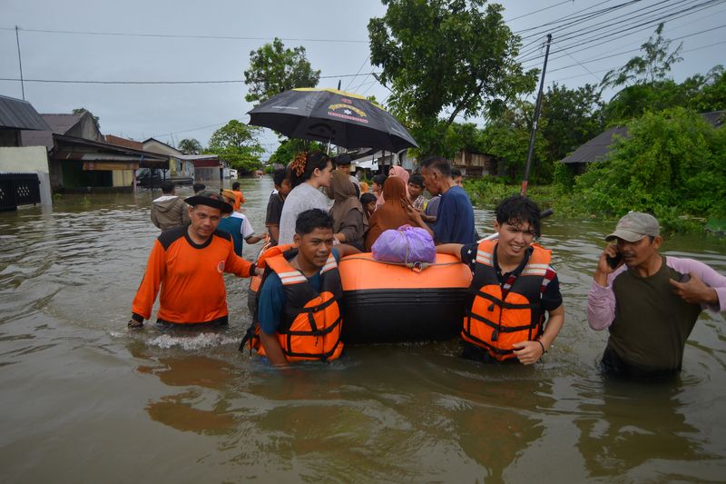 &copy; Reuters. Local Disaster Management Agency (BPBD) officers use an inflatable boat to evacuate locals at a residential area affected by floods due to heavy rains, in Padang, West Sumatra province, Indonesia, March 8, 2024, in this photo taken by Antara Foto. Antara 