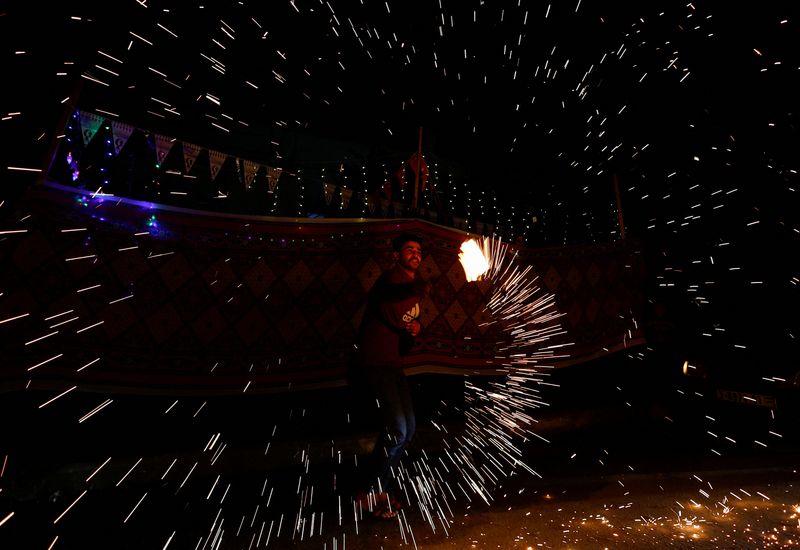 &copy; Reuters. A man spins a homemade sparkler firework as displaced Palestinians prepare their tents for Ramadan, amid the ongoing conflict between Israel and the Palestinian Islamist group Hamas, in Rafah, in the southern Gaza Strip March 9, 2024. REUTERS/Mohammed Sal