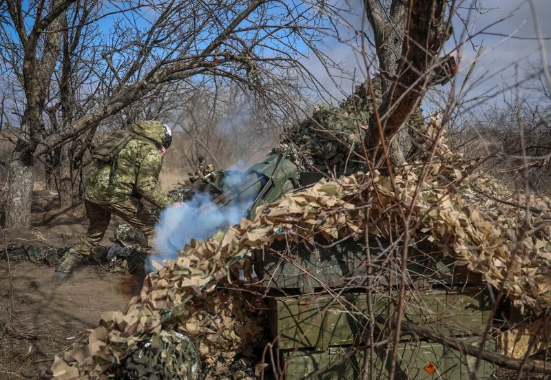 © Reuters. Ukrainian service members fire a 120-mm towed 2B16 