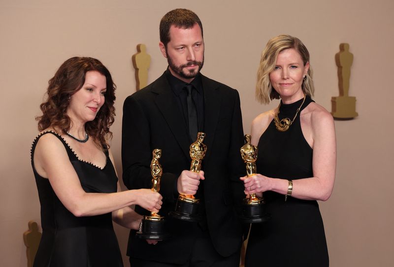 &copy; Reuters. Mstyslav Chernov, Michelle Mizner and Raney Aronson - Rath pose with the Oscar for Best Documentary Feature Film for "20 Days in Mariupol" in the Oscars photo room at the 96th Academy awards in Hollywood, Los Angeles, California, U.S., March 10, 2024.   R