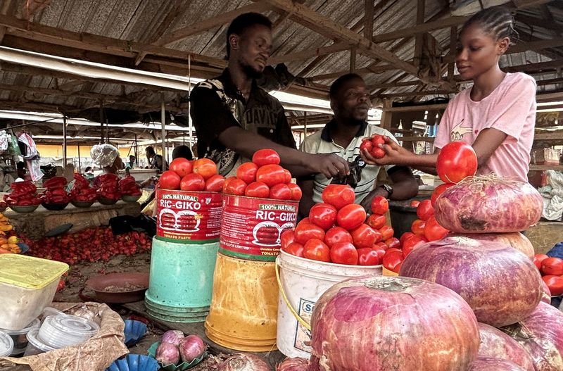 &copy; Reuters. Farouk Dalhatu, a tomatoes seller attends to buyer in a community market of Agodo in Lagos, Nigeria March 6, 2024. REUTERS/Seun Sanni/file photo