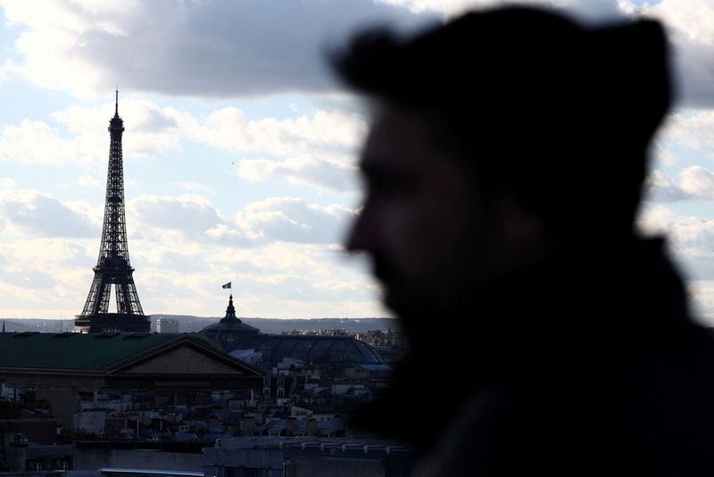 © Reuters. FILE PHOTO: A tourist looks at the Eiffel Tower and the Paris skyline from the rooftop of the Galeries Lafayette department store on a winter day in Paris, France, January 15, 2024. REUTERS/Stephanie Lecocq/File Photo