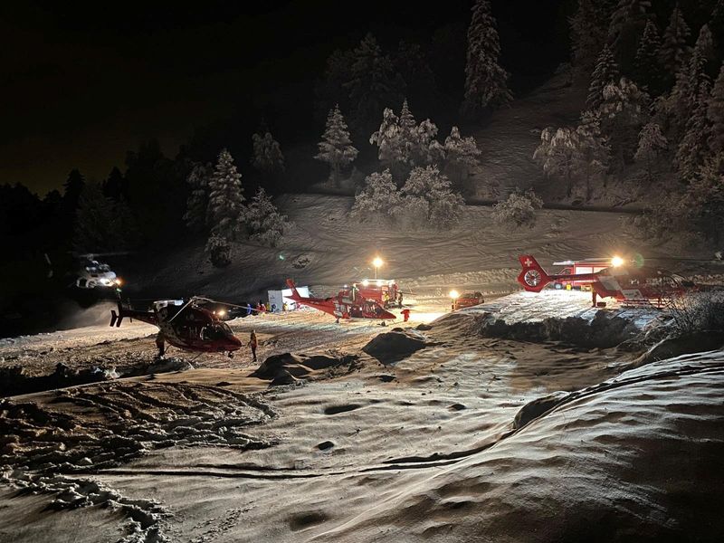 © Reuters. Helicopters are pictured during a rescue operation after six touring skiers went missing, in Evolene, Switzerland, in this handout picture released on March 11, 2024. Police Cantonale Valaisanne/Handout via REUTERS 