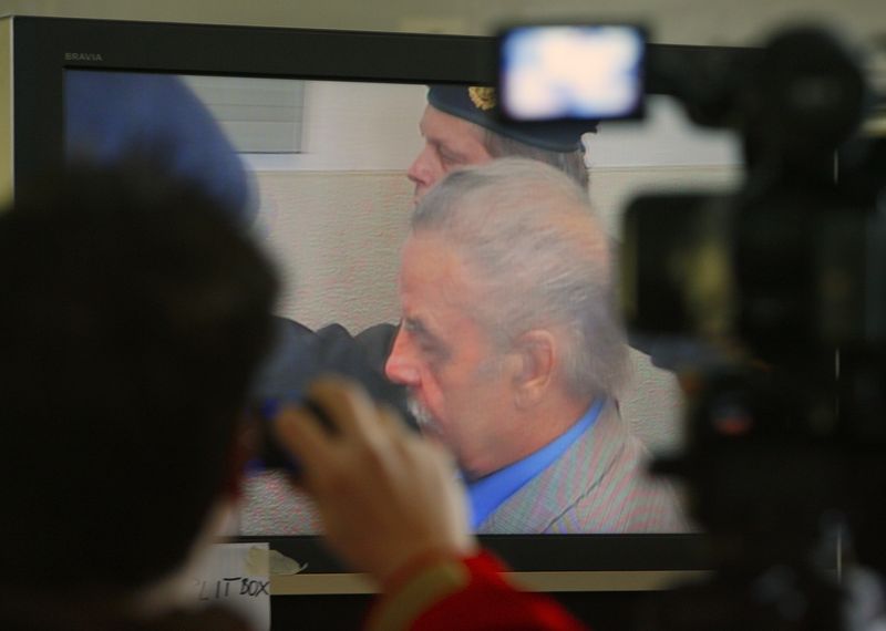 &copy; Reuters. FOTO DE ARCHIVO. Periodistas miran una pantalla de televisión dentro de la carpa de los medios mientras el austriaco Josef Fritzl comparece ante el tribunal en el cuarto día de su juicio en St. Poelten, Austria, el 19 de marzo de 2009. REUTERS/Heinz-Pet