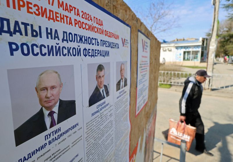 &copy; Reuters. FILE PHOTO: A man walks past an information board with portraits of Russian presidential candidates in the upcoming election in Yevpatoriya, Crimea March 8, 2024. REUTERS/Alexey Pavlishak/File Photo