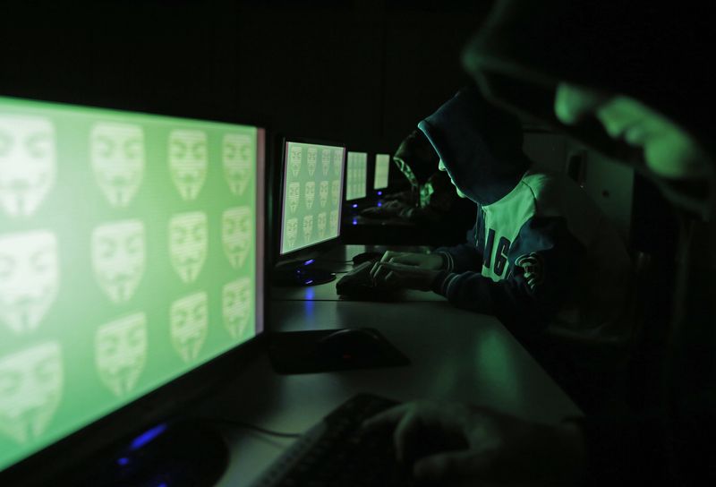 &copy; Reuters. FOTO DE ARCHIVO. Imagen de ilustración de un grupo de personas posa ante una pantalla que muestra la palabra "ciber" en código binario. 27 de diciembre de 2014. REUTERS/Dado Ruvic