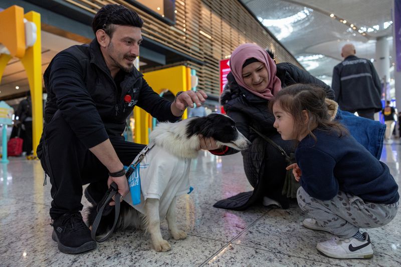 &copy; Reuters. مسافرون يداعبون أحد الكلاب المدربة للمساعدة في تهدئة أعصاب المسافرين بمطار إسطنبول يوم الاثنين. تصوير: أوميت بكطاش - رويترز