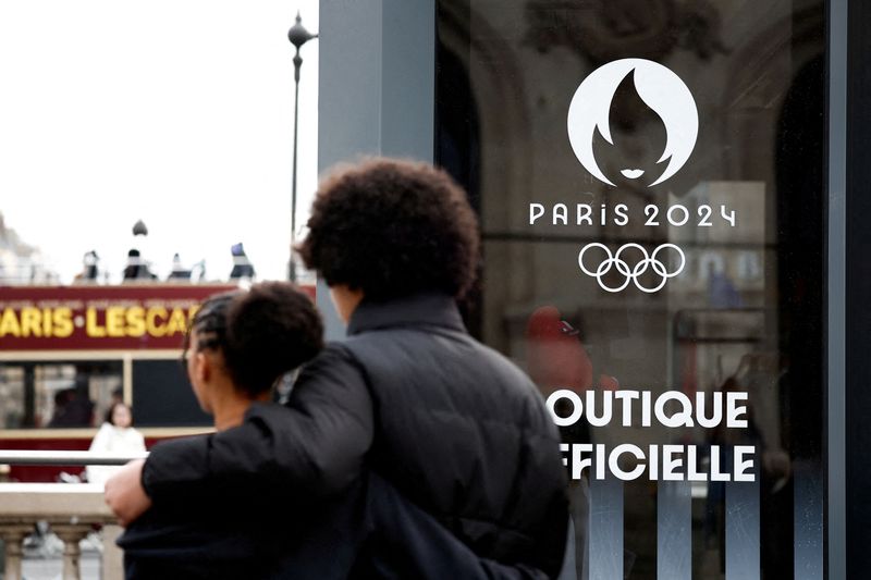 &copy; Reuters. FILE PHOTO: People walk near the logo of the Paris 2024 Olympic and Paralympic Games on an official Paris 2024 store at Place de l'Opera in Paris, France, January 1, 2024. REUTERS/Benoit Tessier/File Photo