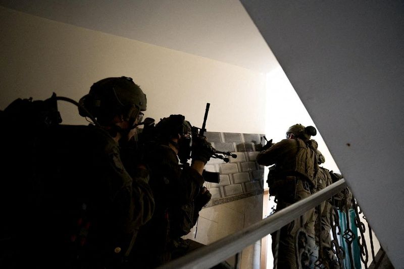 © Reuters. جنود إسرائيليون خلال عملية في قطاع غزة في صورة حصلت عليها رويترز من الجيش الإسرائيلي يوم الاثنين .  