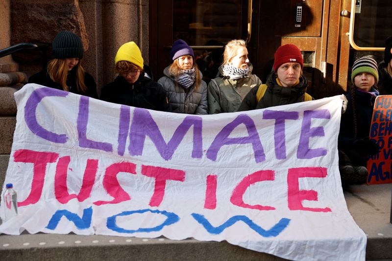 &copy; Reuters. 　３月１１日、スウェーデンの環境活動家グレタ・トゥンベリさん（中央）と環境活動家ら数十人が、気候変動による影響と政治的無為を批判するとして、主要な議会入り口をふさぐ座り込