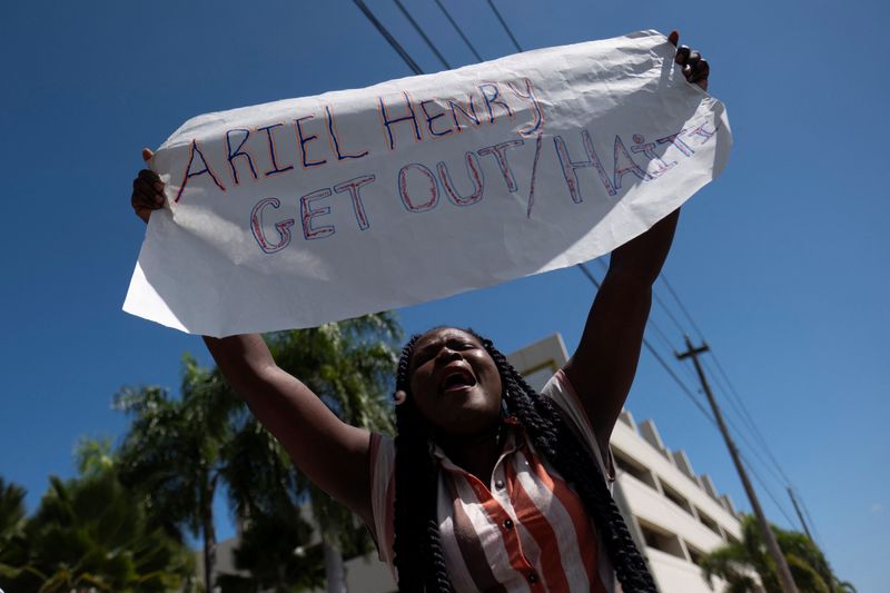 &copy; Reuters. Une femme manifeste devant un hôtel où semble résider le Premier ministre haïtien Ariel Henry, à San Juan, à Porto Rico. /Photo prise le 8 mars 2024/REUTERS/Ricardo Arduengo