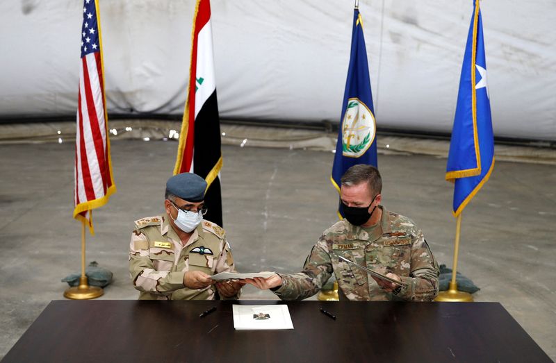 &copy; Reuters. FILE PHOTO: Maj. Gen. Kenneth P. Ekman, Deputy Commander of Combined Joint Task Force-Operation Inherent Resolve, signs documents with Brigadier General Salah Abdullah during a handover ceremony of Taji military base from US-led coalition troops to Iraqi 