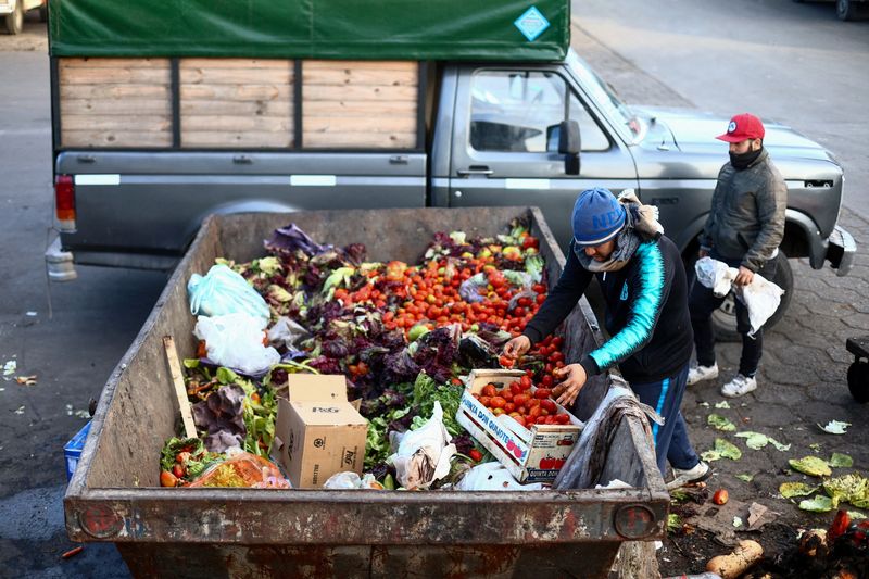 &copy; Reuters. FILE PHOTO: A man collects food from a container where discarded fruits and vegetables are deposited at the Mercado Central, the city's largest wholesale central market, which receives produce from the entire country, as Argentines face a daily race for d