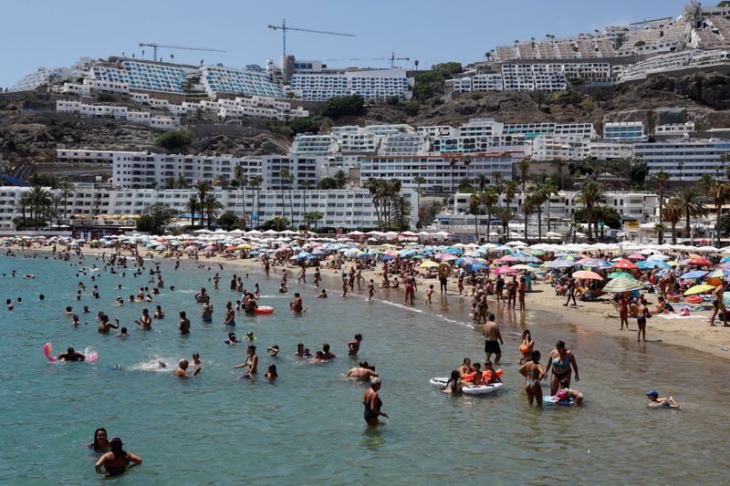 &copy; Reuters. FILE PHOTO: Tourists bathe and sunbathe on the beach of Puerto Rico in the south of the island of Gran Canaria, Spain, August 6, 2023. REUTERS/Borja Suarez/File Photo