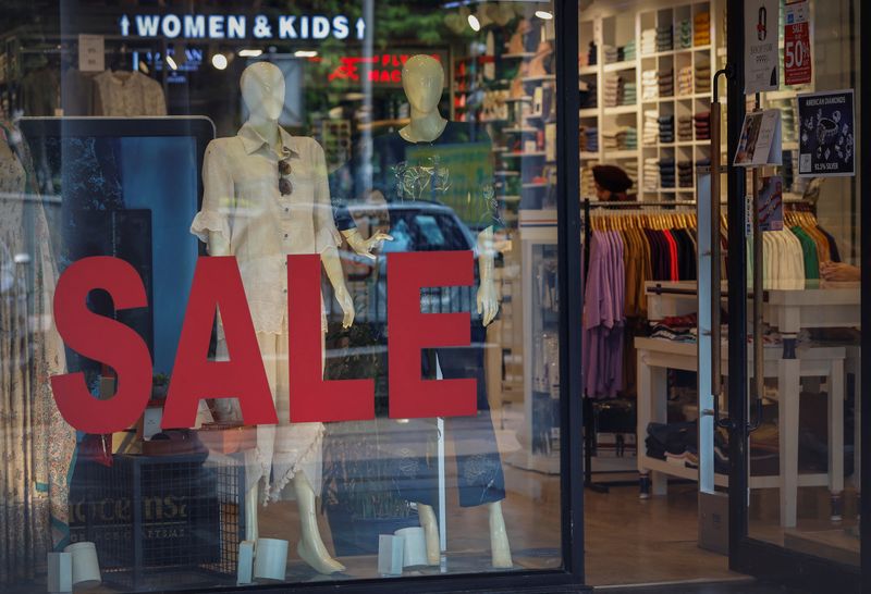 &copy; Reuters. A salesman stands inside a retail store with a sign advertising a sale in New Delhi, India August 21, 2023. REUTERS/Adnan Abidi/File Photo