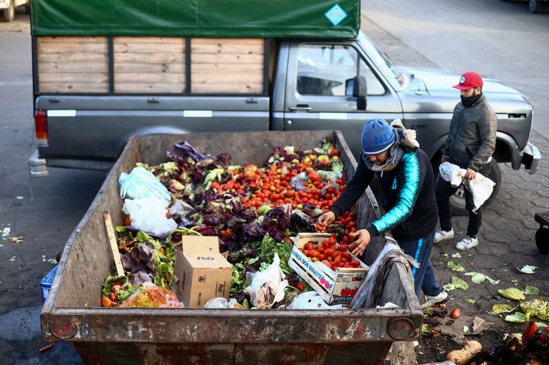 &copy; Reuters. Homem recolhe comida em contêiner onde alimentos são descartados no Mercado Central de Buenos Aires
12/09/2023 REUTERS/Matias Baglietto
